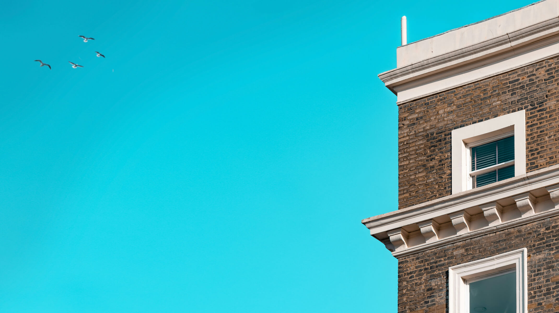 Brown brick building upon a clear teal blue sky